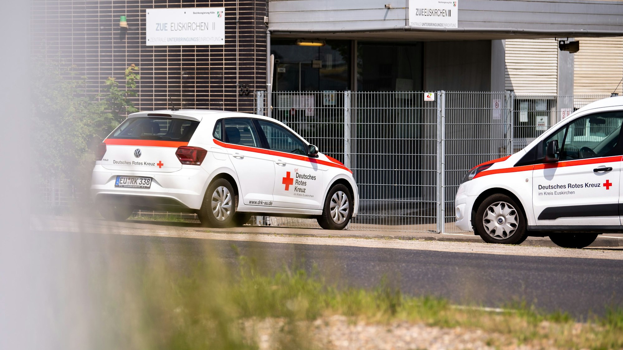 Vor der Geflüchtetenunterkunft in Euskirchen stehen zwei Fahrzeuge des DRK, das die Einrichtung betreibt.