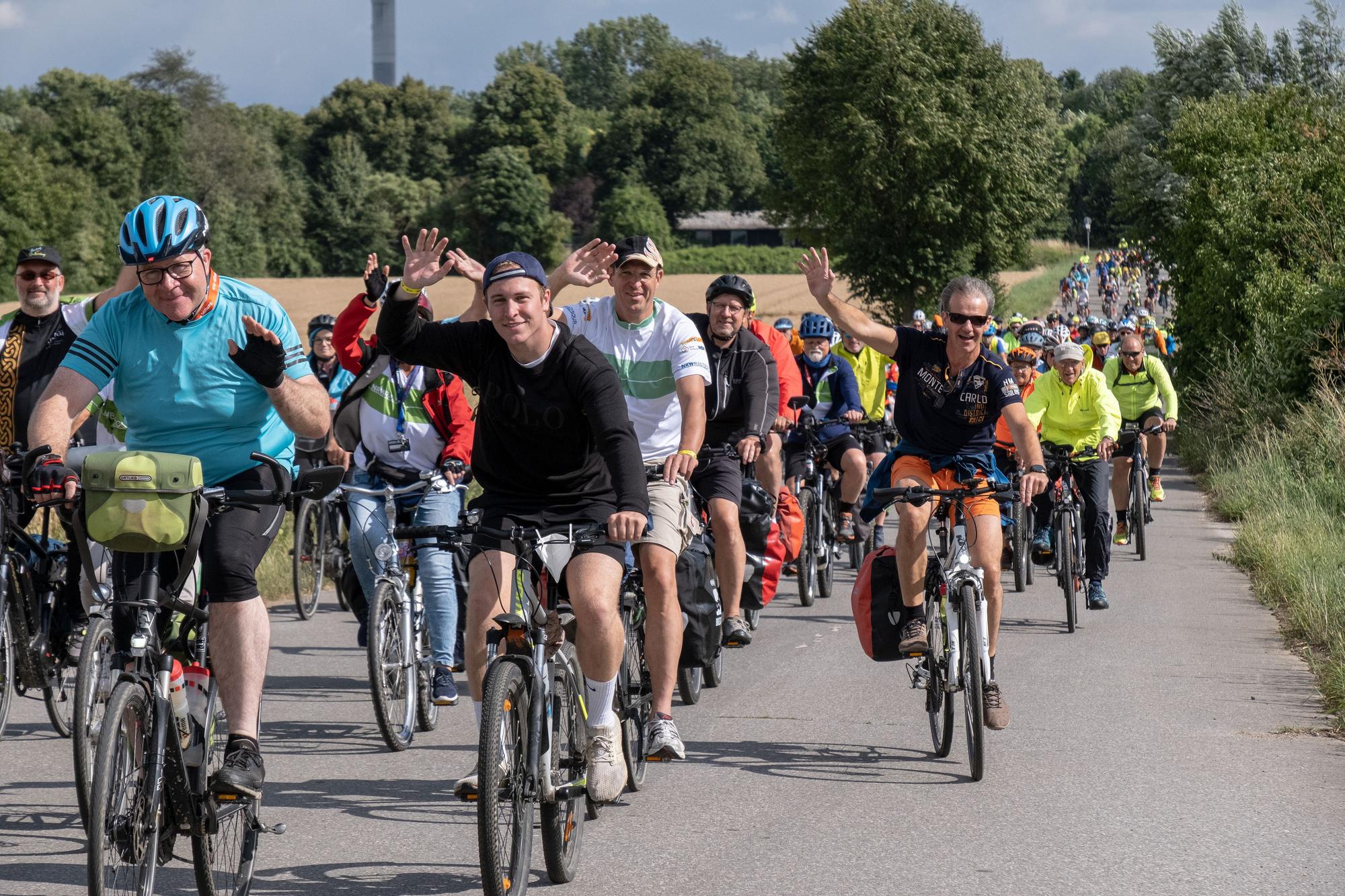 NRW-Radtour 2022, viele Radfahrer als Kolonne auf der Straße.
