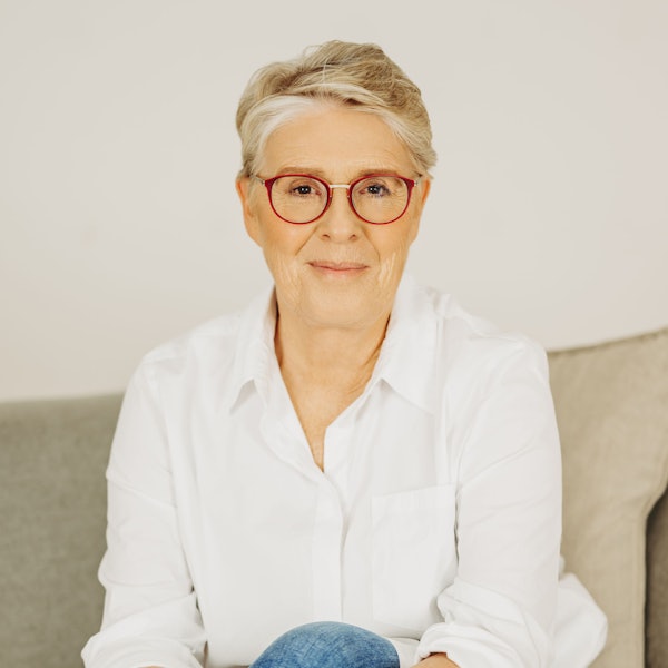 Eine Frau mit Brille lächelt.