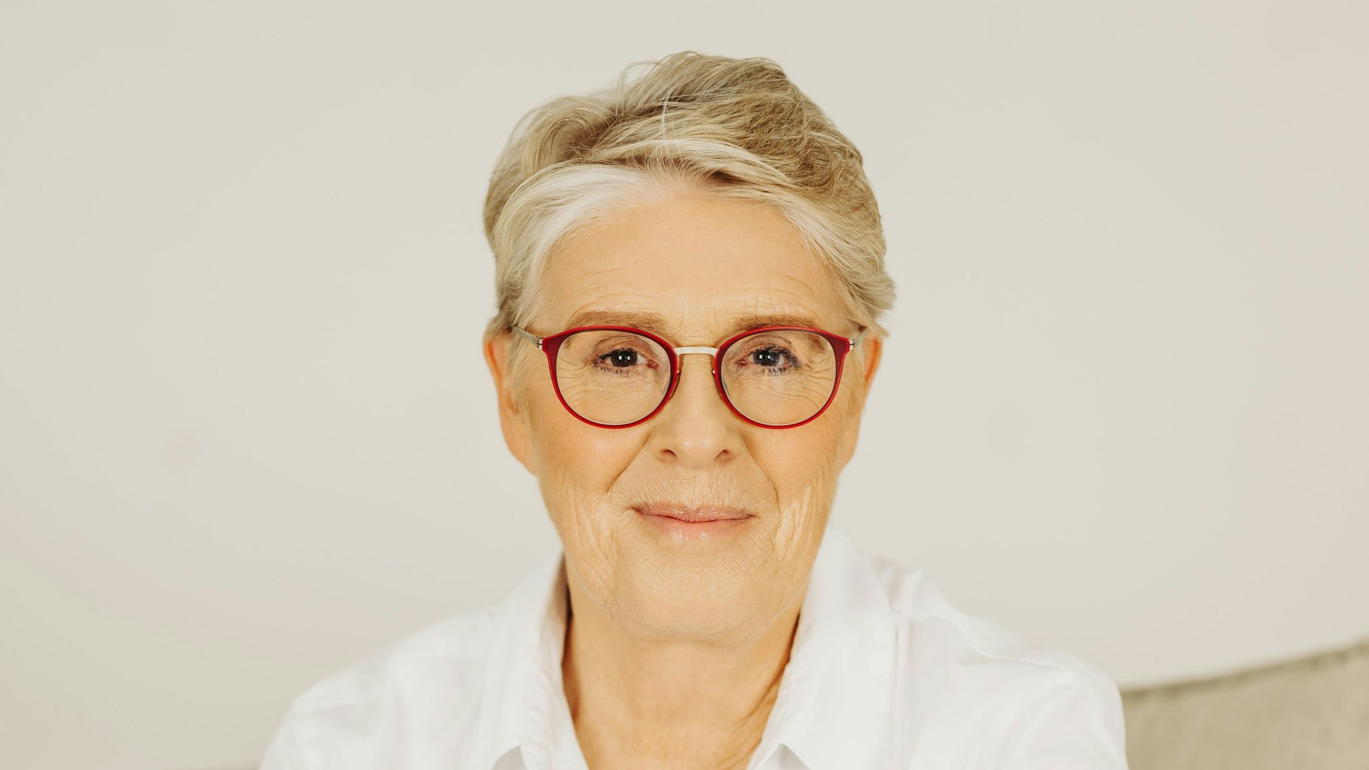 Eine Frau mit Brille lächelt.