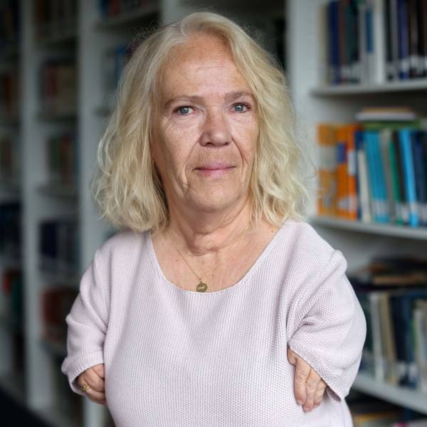 Bianca Vogel steht vor einem Bücherregal