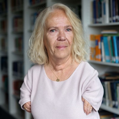 Bianca Vogel steht vor einem Bücherregal