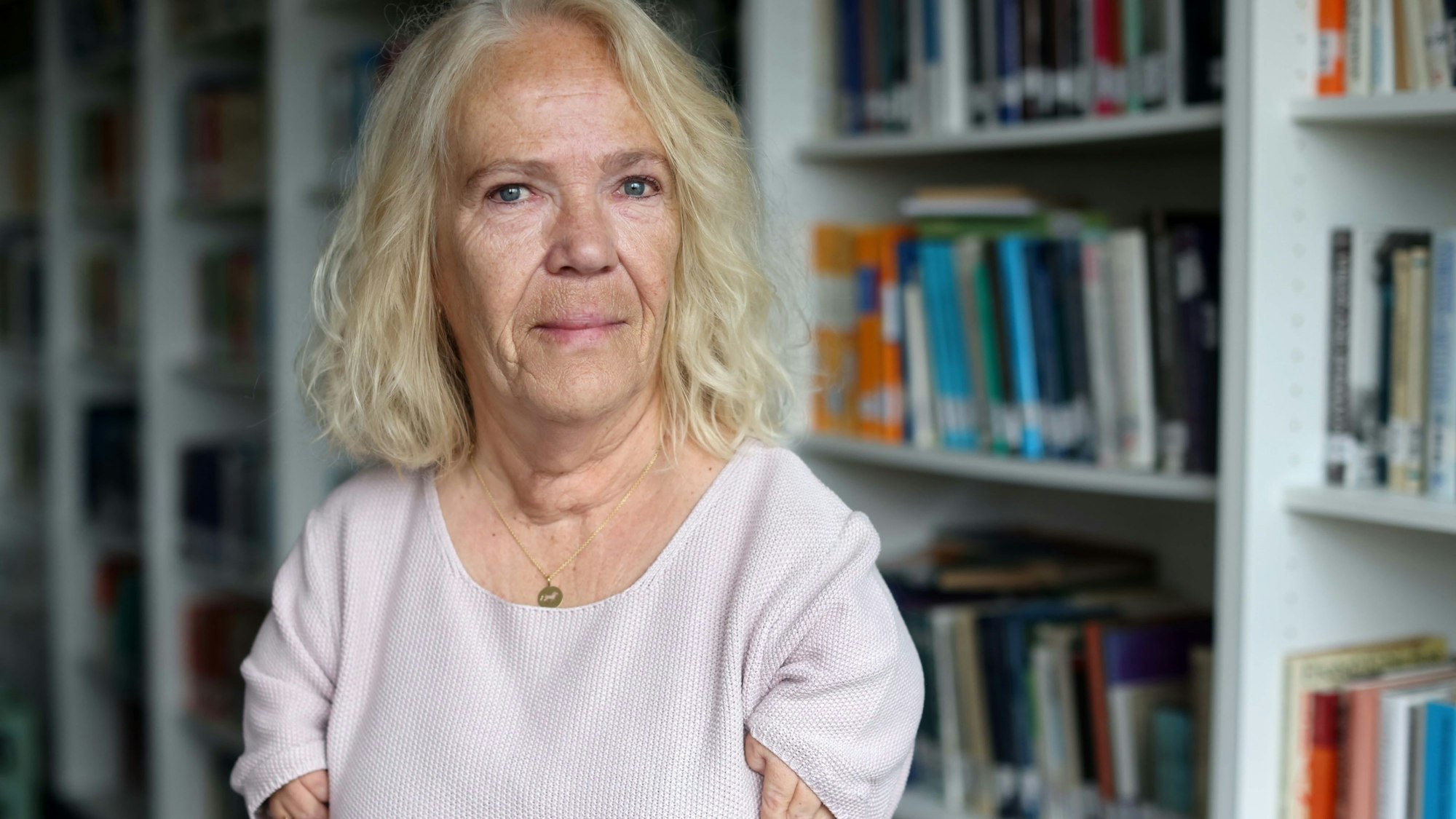 Bianca Vogel steht vor einem Bücherregal