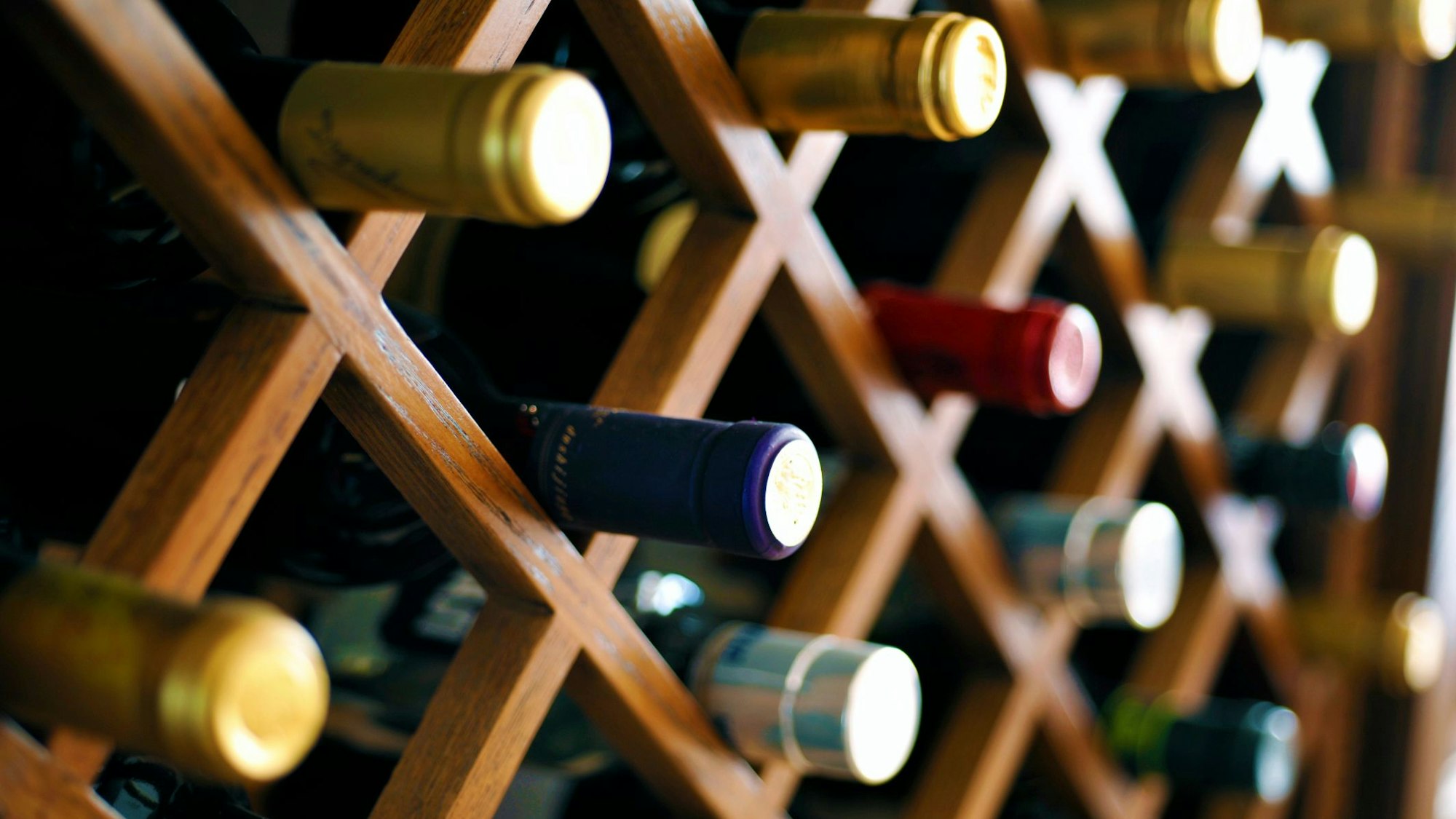 Weinflaschen liegen in einem Regal.