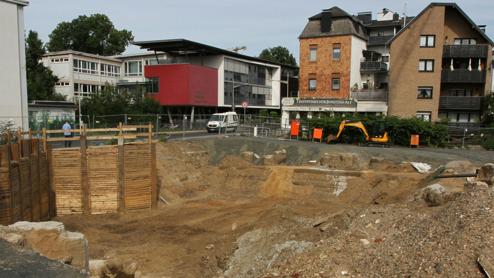 Eine Baugrube mit einer Häuserzeile im Hintergrund
