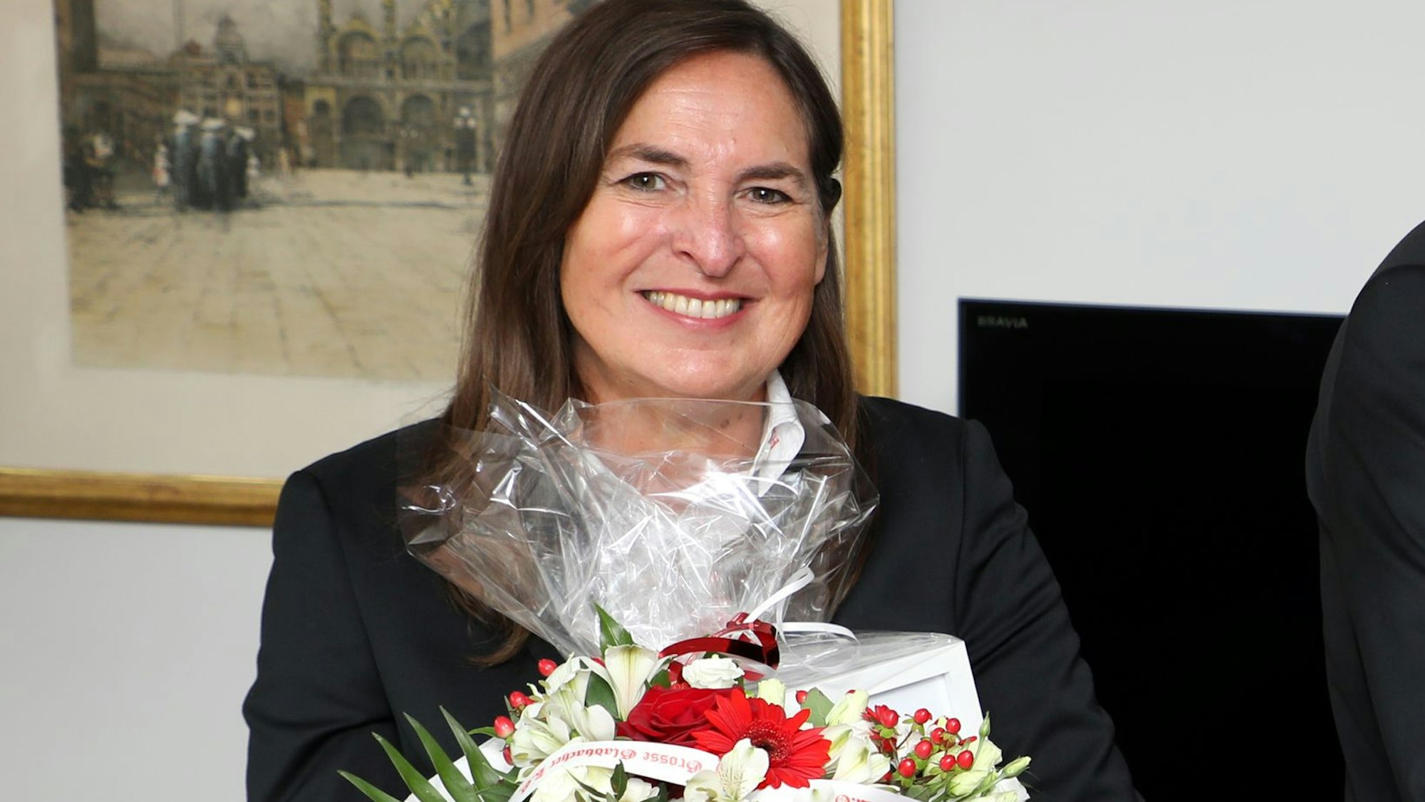 Eine Frau hält einen Blumenstrauß in den Händen.