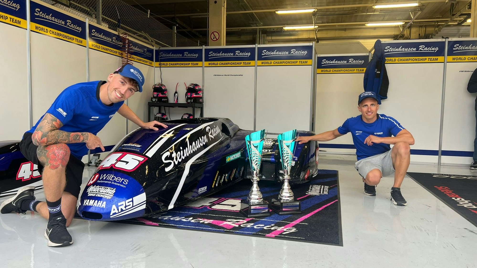 Zwei Teammitglieder des Steinhausen Racing Teams aus Nümbrecht knien neben einem Seitenwagen.