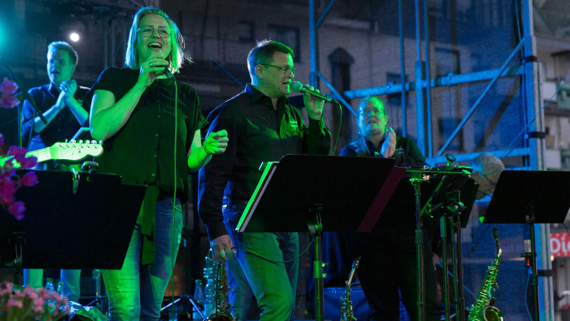 Eine Frau und ein Mann singen auf der Bühne in Mikrofone.