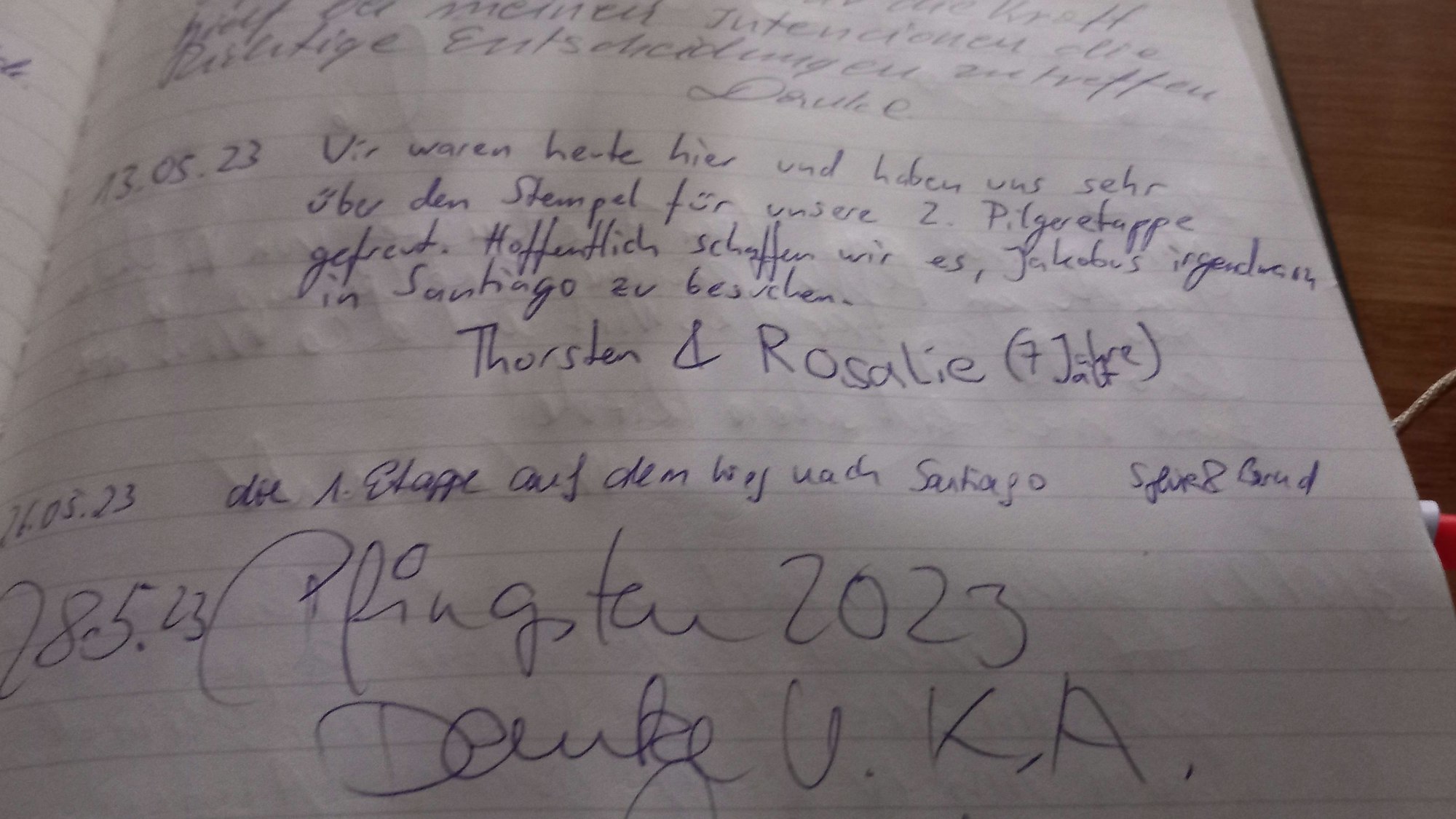 In einem Pilgerbuch haben sich Pilger eingetragen.