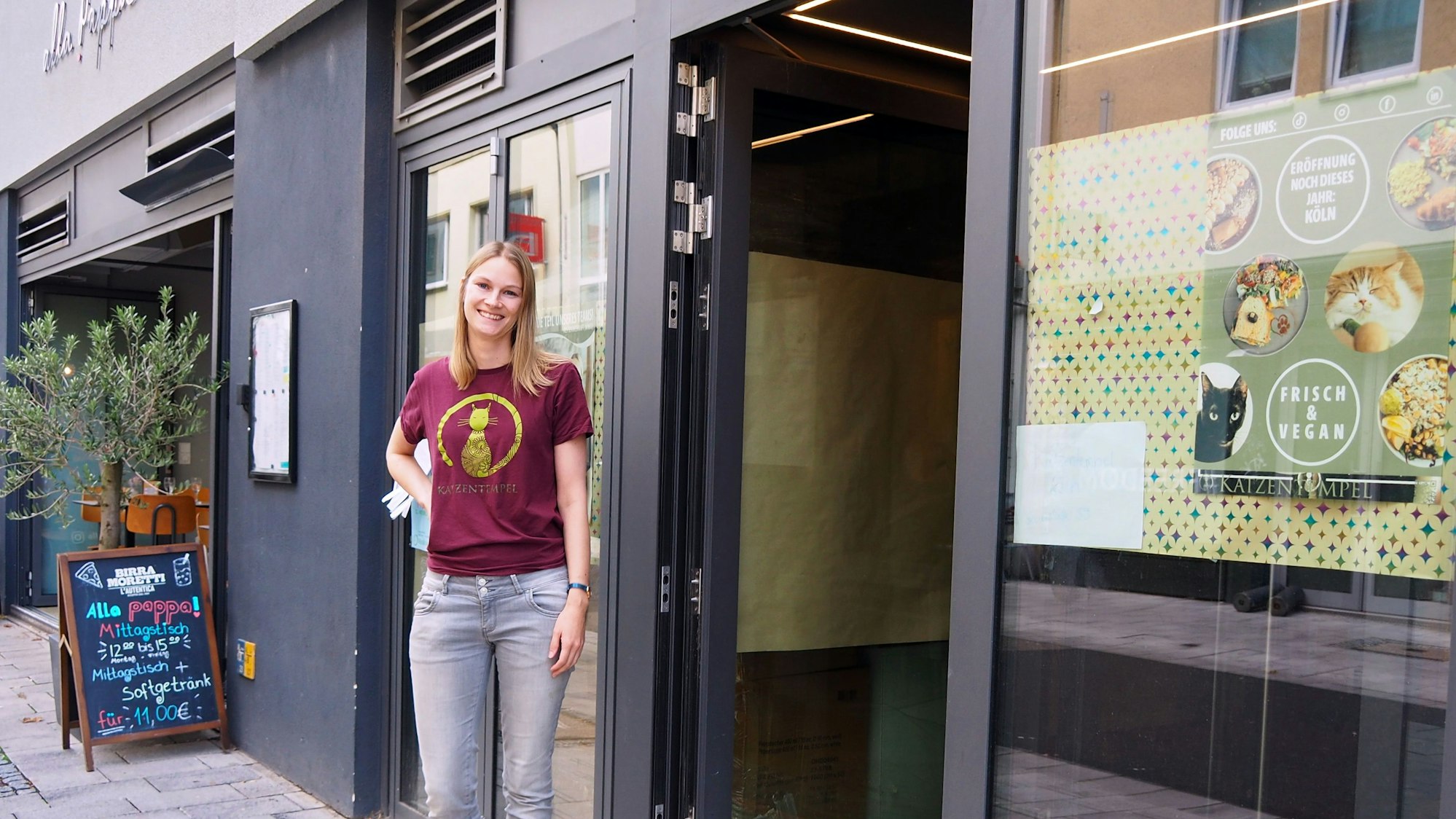 Die Betreiberin steht vor dem Geschäftseingang.