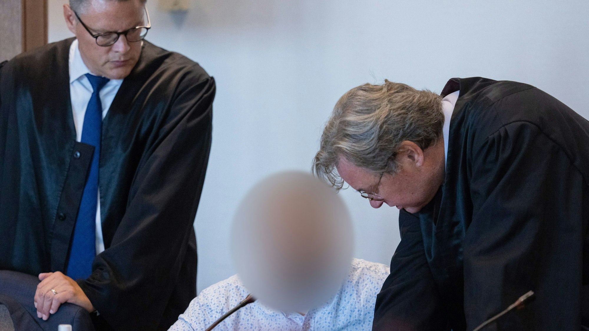 Einer der beiden Hauptangeklagten sitzt zu Beginn des Prozess wegen Betrugs mit Corona-Tests im Landgericht neben seinen Anwälten.