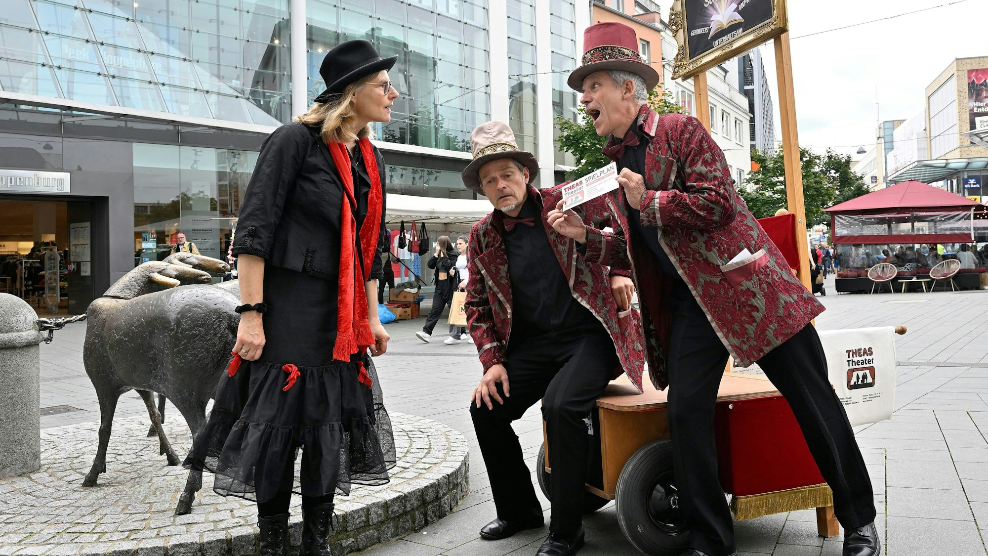 In der Bergisch Gladbacher Fußgängerzone ließ sich Theas-Intendantin Claudia Timpner von Moritz Möller und Udo Passon (v.l.) in eine Spielszene einbinden.