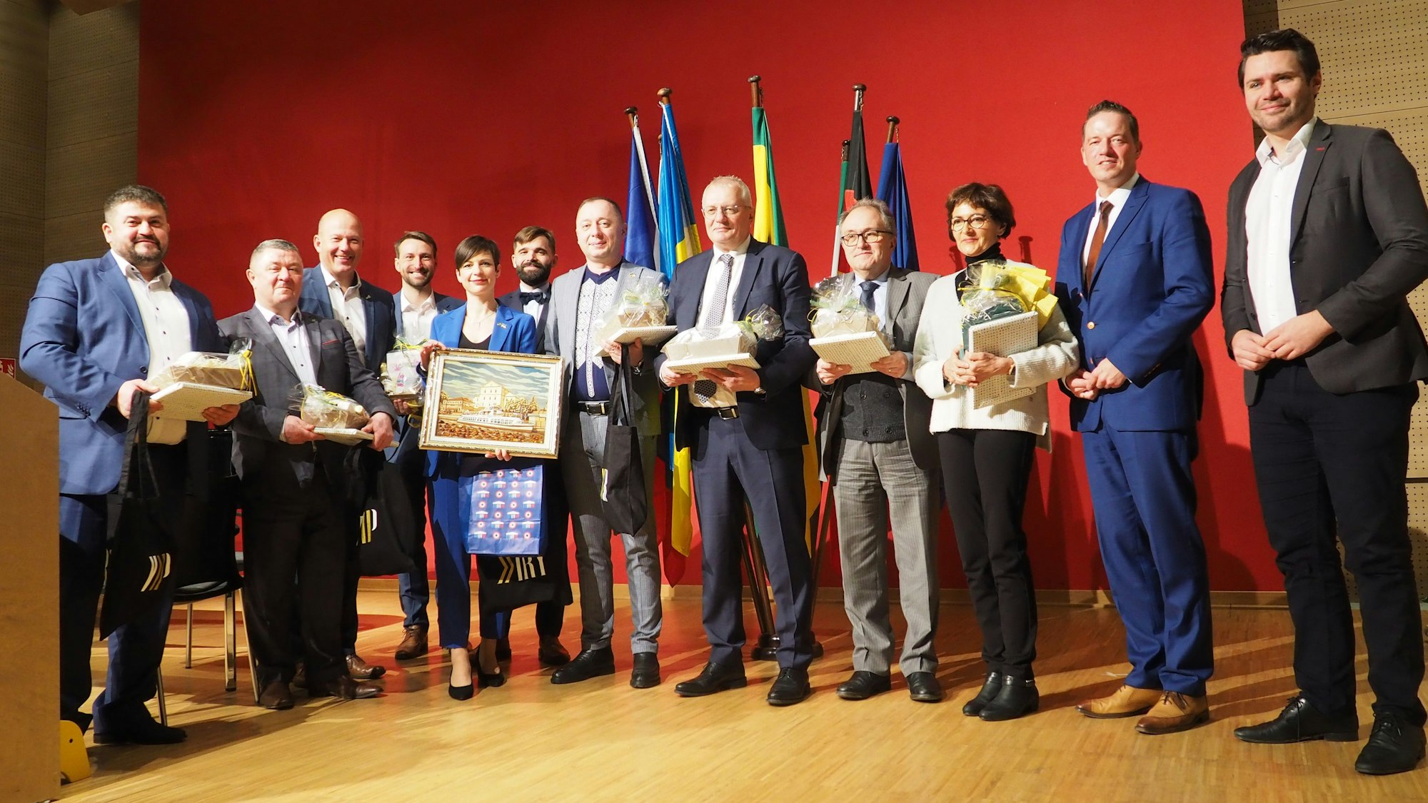 Viele Menschen stehen im Halbkreis auf der Bühne. 1