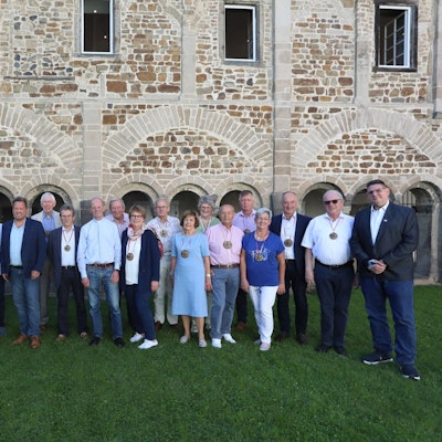 Eine Gruppe von Männern und Frauen stehen nebeneinander, fast alle tragen den Orden Ritter vom Siebengebirge.