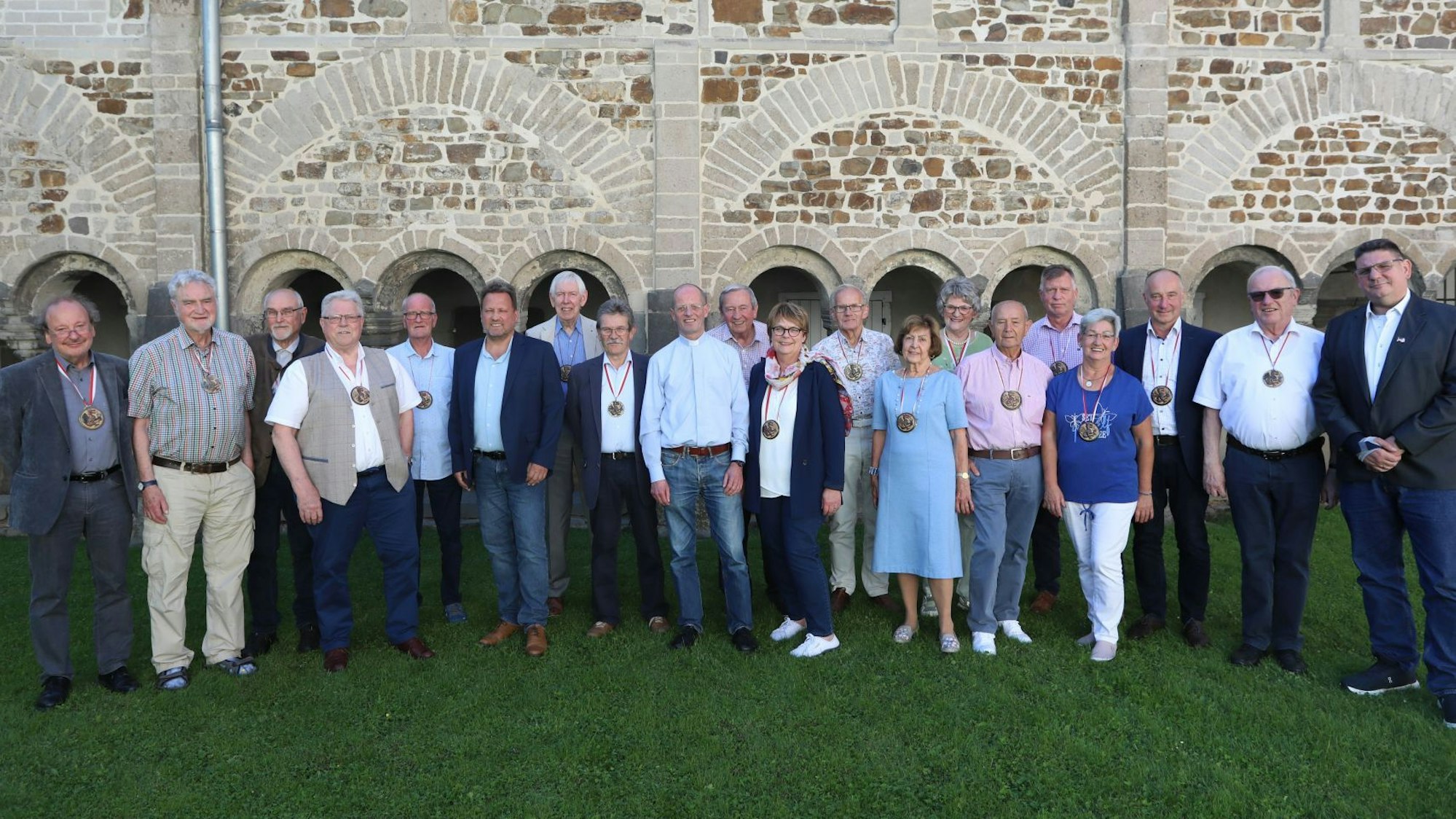 Eine Gruppe von Männern und Frauen stehen nebeneinander, fast alle tragen den Orden Ritter vom Siebengebirge.