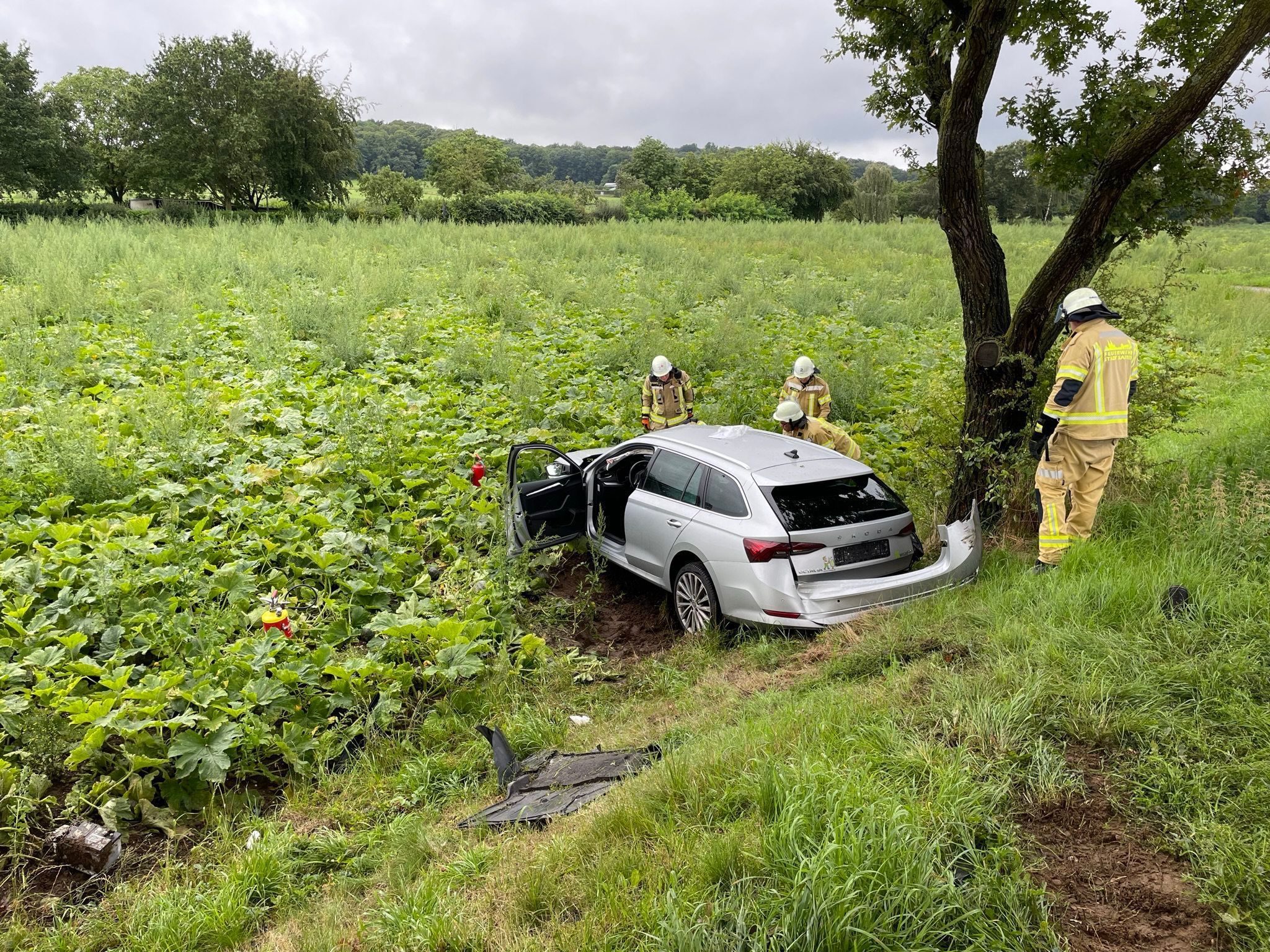 Einsatzkräfte untersuchen ein Autowrack.