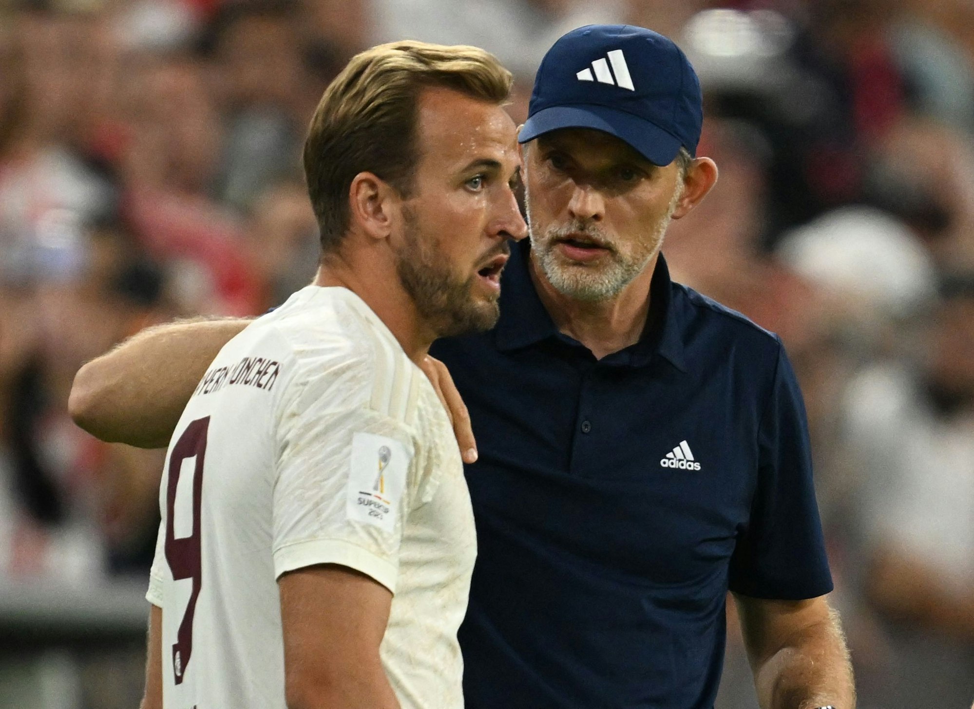 Bayerns Cheftrainer Thomas Tuchel (r.) weist Harry Kane vor seinem Debüt gegen RB Leipzig im Supercup ein.