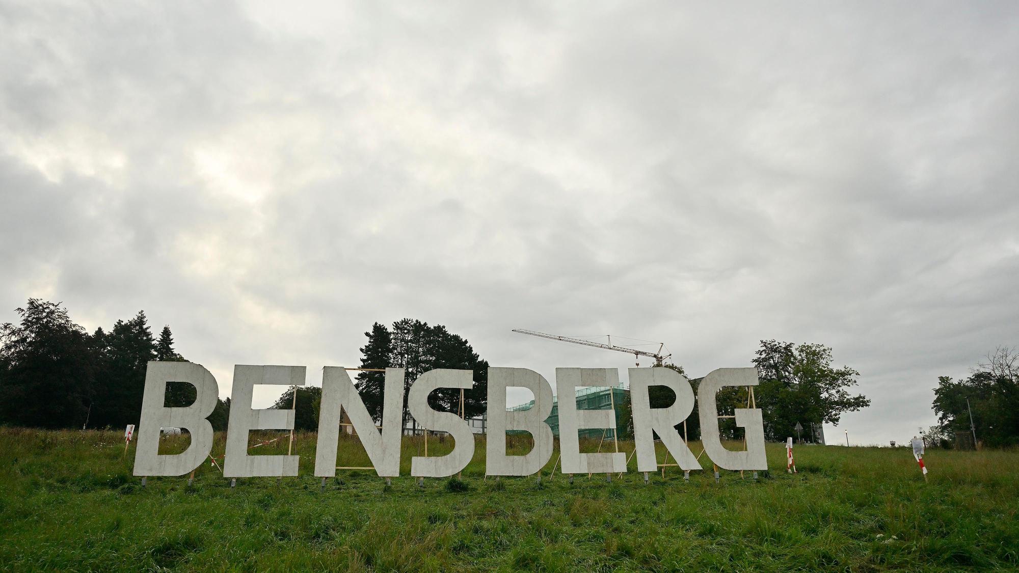 Die riesigen acht Großbuchstaben BENSBERG sind weiß angemalt und stehen auf der Kuppe der Wiese des Stadtgartens unterhalb des Vinzenz-Pallotti-Hospitals.