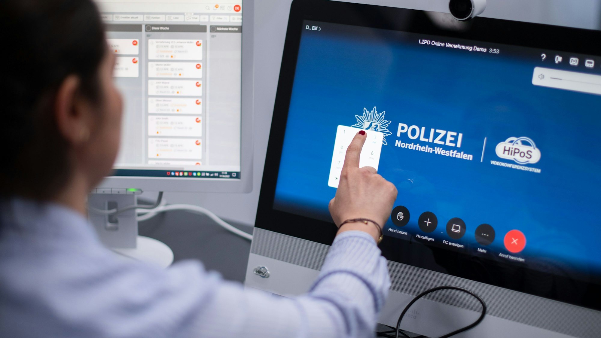 Eine Polizistin wählt sich während einer Pressevorführung zur Onlinevernehmung in einen digitalen Vernehmungsraum ein.