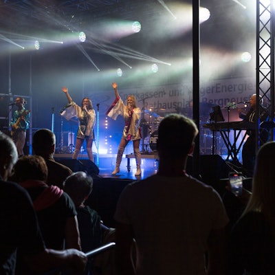 Zwei Sängerinnen stehen auf der Bühne, im Vordergrund das Publikum.