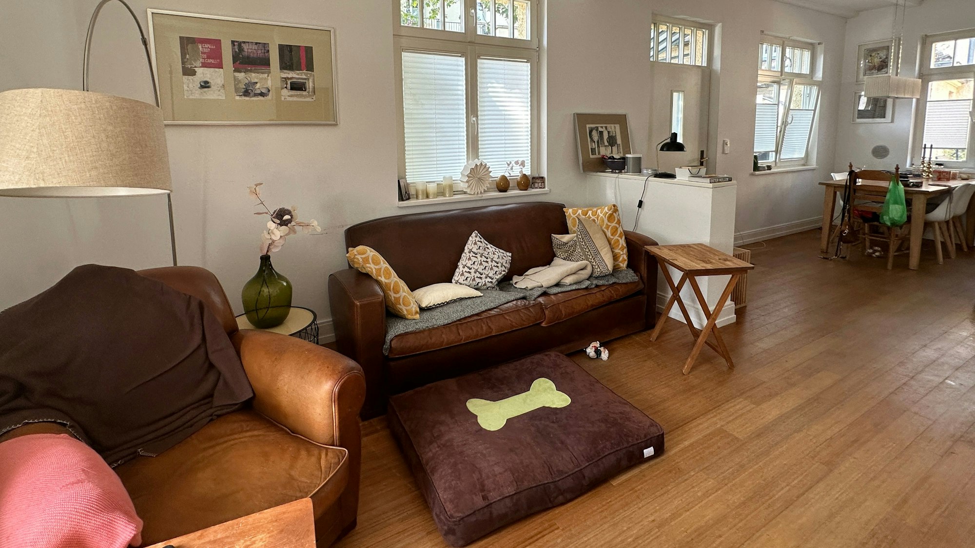 Ein Wohnzimmer mit Polstermöbeln und einer Essecke ist zu sehen.