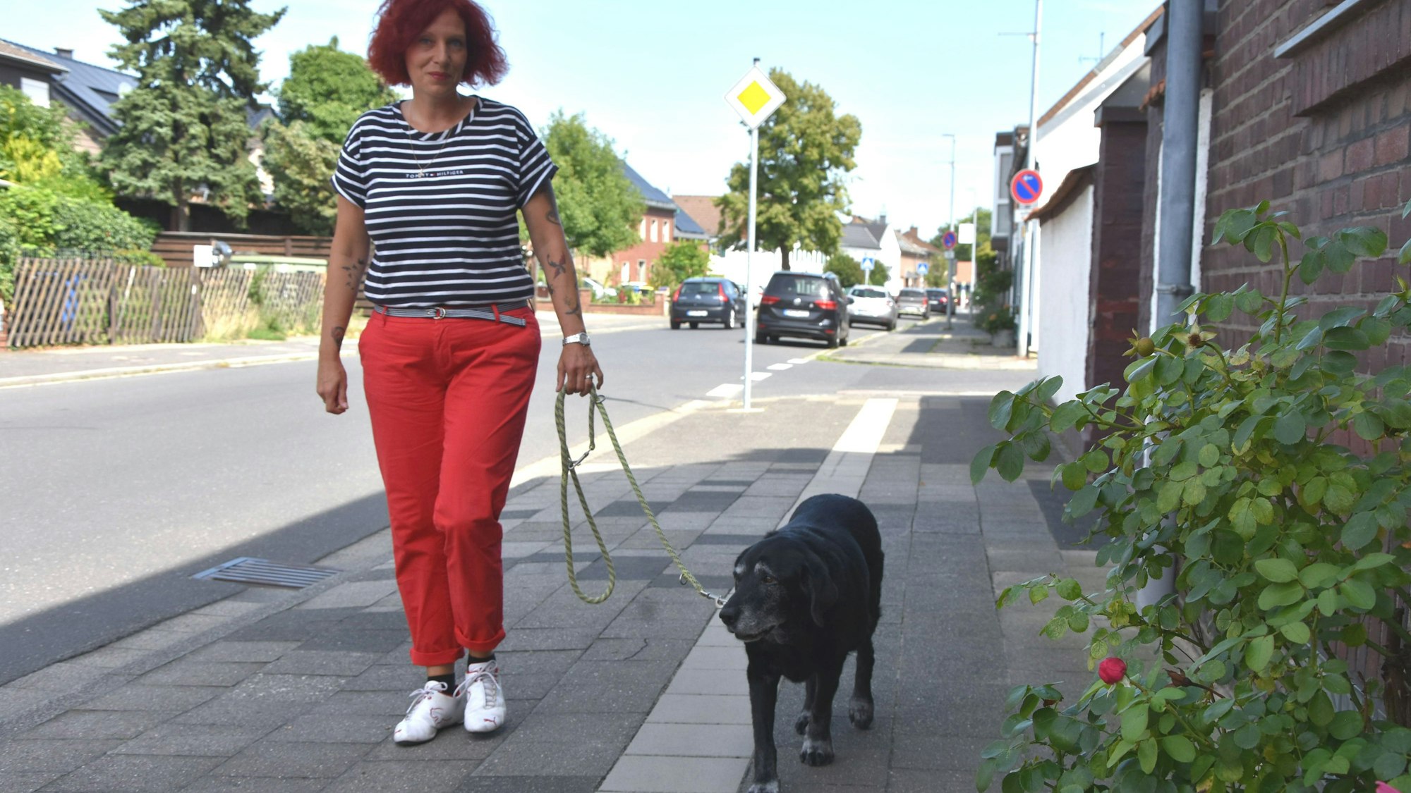 Das Foto zeigt Halterin Alexandra Jakubowski, die ihre Hündin an der Leine über einen Gehweg führt.