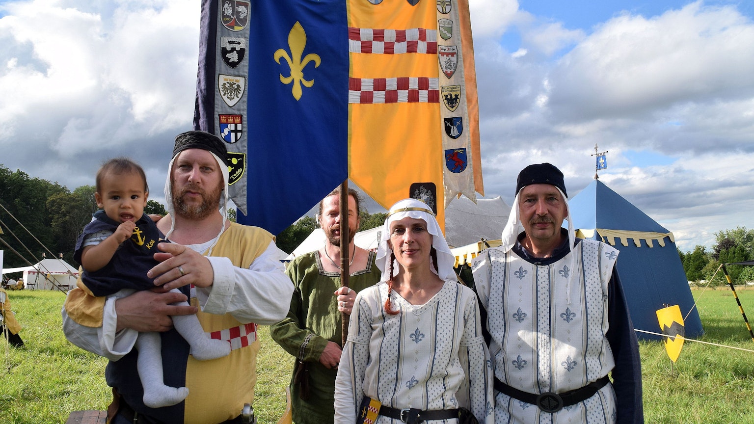14. August 2023. Rheinbach. Ritterschlag der Tomburg Ritter. Ritter Elmar von der Drachenlilie (Elmar Sann, rechts) schlug Axel Schregel (links) zum Ritter Hektor Hopfenschreck von der Stierau. Mit im Bild Wappenträger Kai Hoffmann und die Vorsitzende der Tomburg Ritter, Annegret Sann.