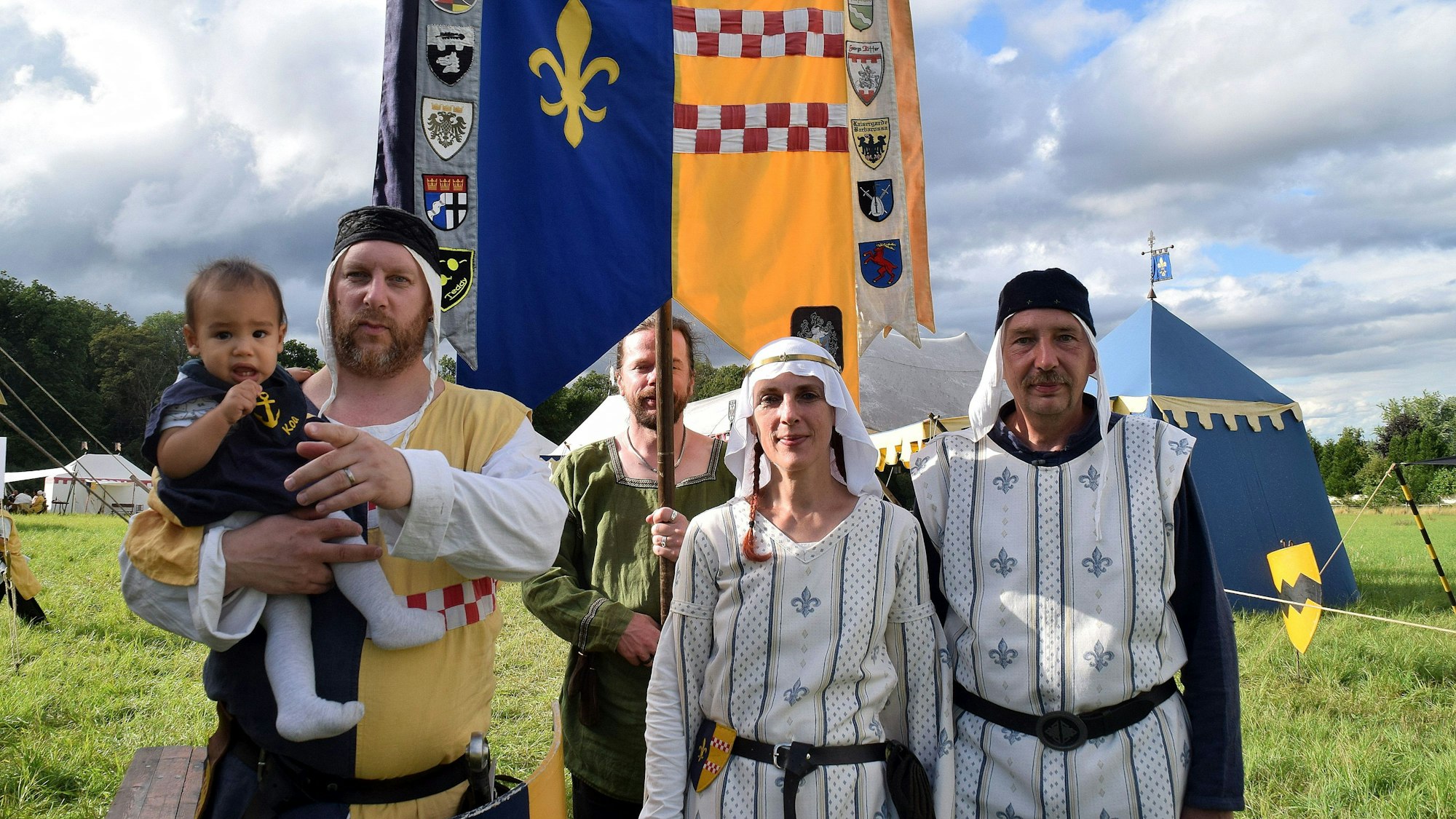 14. August 2023. Rheinbach. Ritterschlag der Tomburg Ritter. Ritter Elmar von der Drachenlilie (Elmar Sann, rechts) schlug Axel Schregel (links) zum Ritter Hektor Hopfenschreck von der Stierau. Mit im Bild Wappenträger Kai Hoffmann und die Vorsitzende der Tomburg Ritter, Annegret Sann.