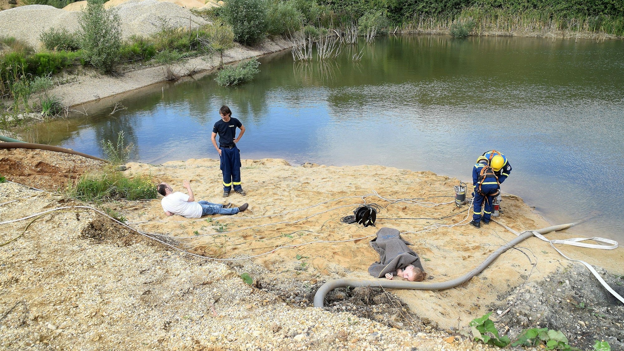 Von einer Anhöhe am Rand des Geländes westlich des Swisttaler Ortsteils Straßfeld ist klar zu sehen, dass es zahlreiche Verletzte gibt. Ein Pärchen liegt reglos am Ufer des Baggersees.