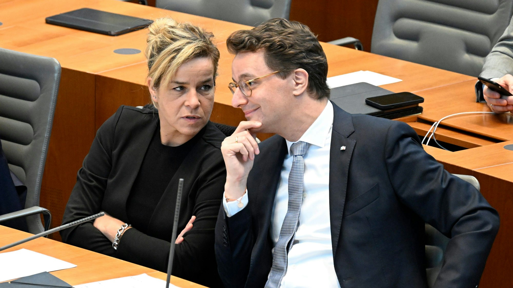 Hendrik Wüst (CDU), Ministerpräsident von Nordrhein-Westfalen, spricht mit seiner Stellvertreterin, Wirtschaftsministerin Mona Neubaur, l, (Grüne) während einer Plenarsitzung.