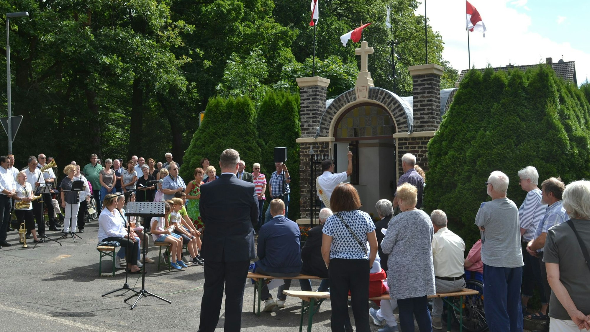 Zahlreiche Menschen stehen in Lessenich vor einem Denkmal.