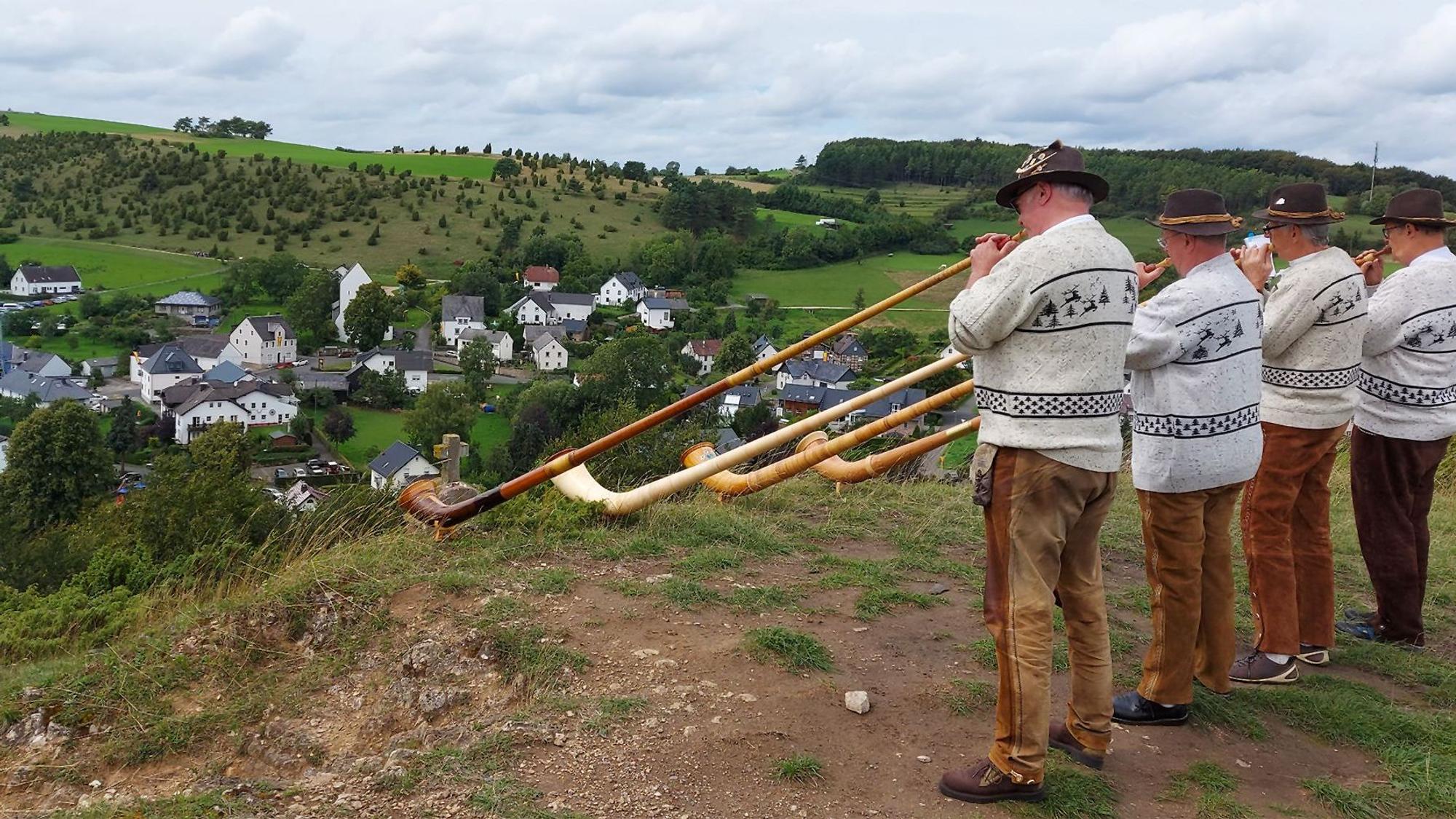 Eine Gruppe Alphornspieler steht auf einer Anhöhe, damit die Klänge ins Tal nach Alendorf getragen werden.