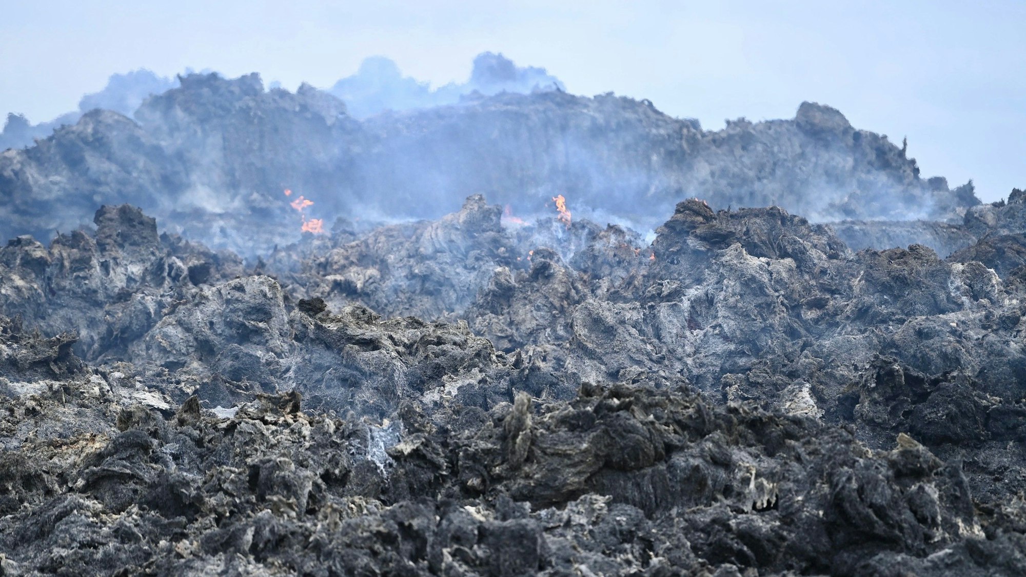 Das Bild zeigt einen Blick auf die Strohmiete. Einzelne Flammen züngeln noch heraus.