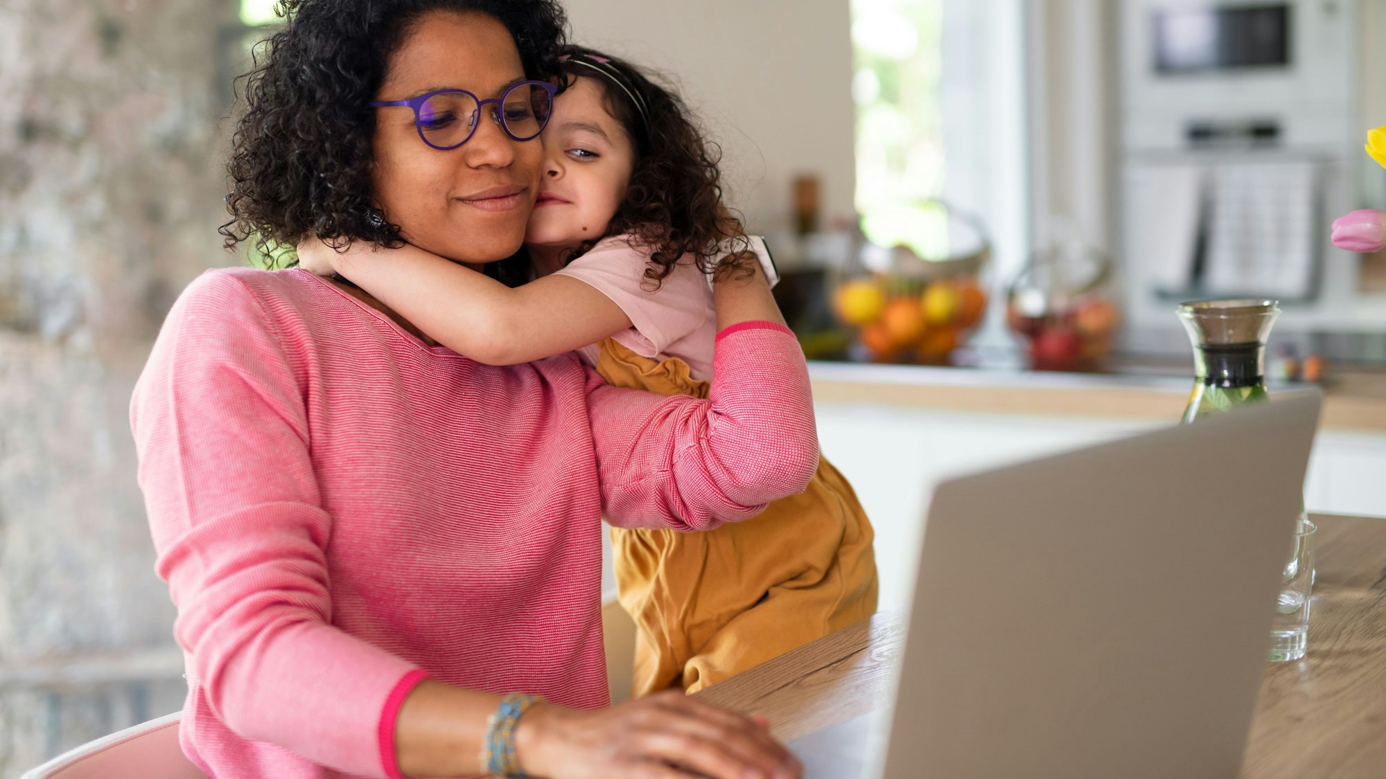 Eine Mutter arbeitet im Homeoffice, gleichzeitig betreut sie ihre Tochter. Laut einer Umfrage übernehmen Frauen in deutschen Haushalten trotz gleicher beruflicher Arbeitsbelastung mehr Aufgaben in Familien. (Symbolbild)
