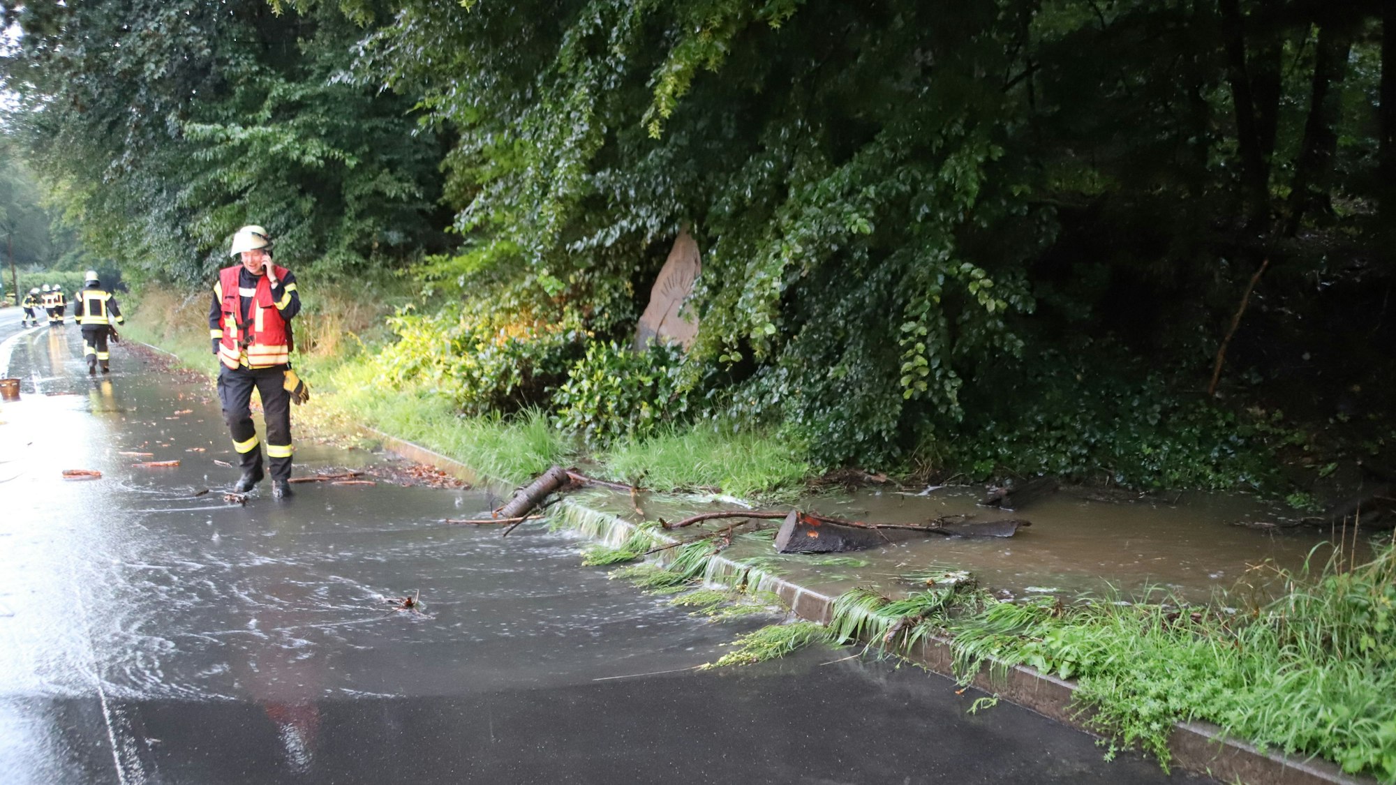 Nach Gewitter und Starkregen gab es zahlreiche Einsätze für die Feuerwehr. In Ruppichteroth-Tanneck floss ein Bach über die K 17, nach dem die Verrohrung unter der Straße am Einlass verstopft war.
