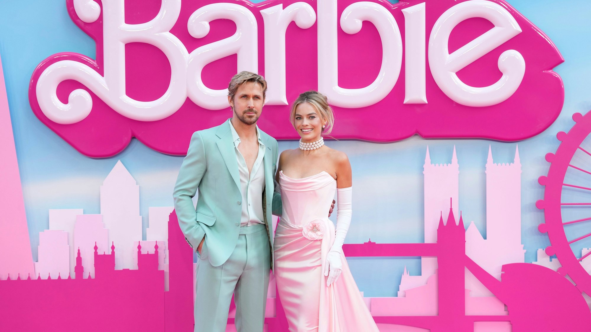 Die Hauptrollen Ryan Gosling (Ken) und Margot Robbie (Barbie) posieren vor einem Filmplakat zum Barbie-Film.