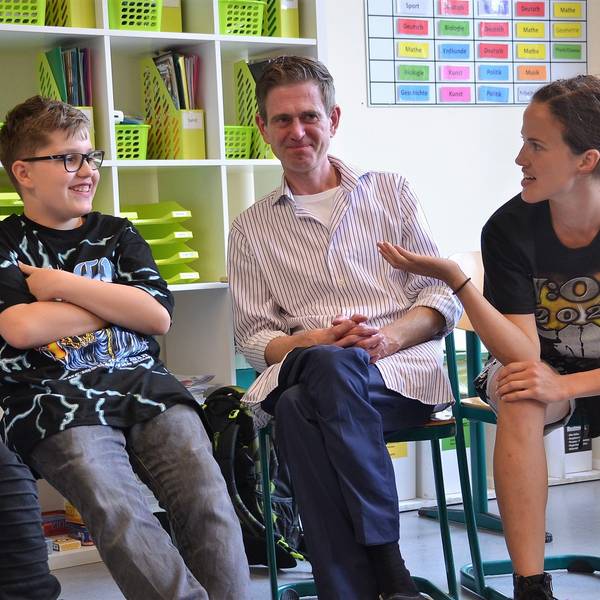 Die beiden Schauspieler Salina Sarhage (v.r.) und Henrik Fockel leiten an der Roseggerschule in Waldbröl einen Kurs, der Schülerinnen und Schüler gegen Mobbing wappnen soll. Hier sitzen sie mit den Kindern in einer Runde und diskutieren über ein Rollenspiel.