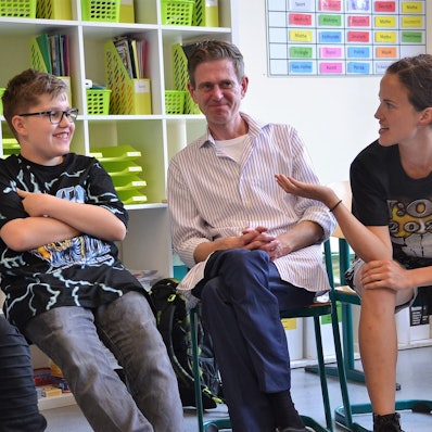 Die beiden Schauspieler Salina Sarhage (v.r.) und Henrik Fockel leiten an der Roseggerschule in Waldbröl einen Kurs, der Schülerinnen und Schüler gegen Mobbing wappnen soll. Hier sitzen sie mit den Kindern in einer Runde und diskutieren über ein Rollenspiel.