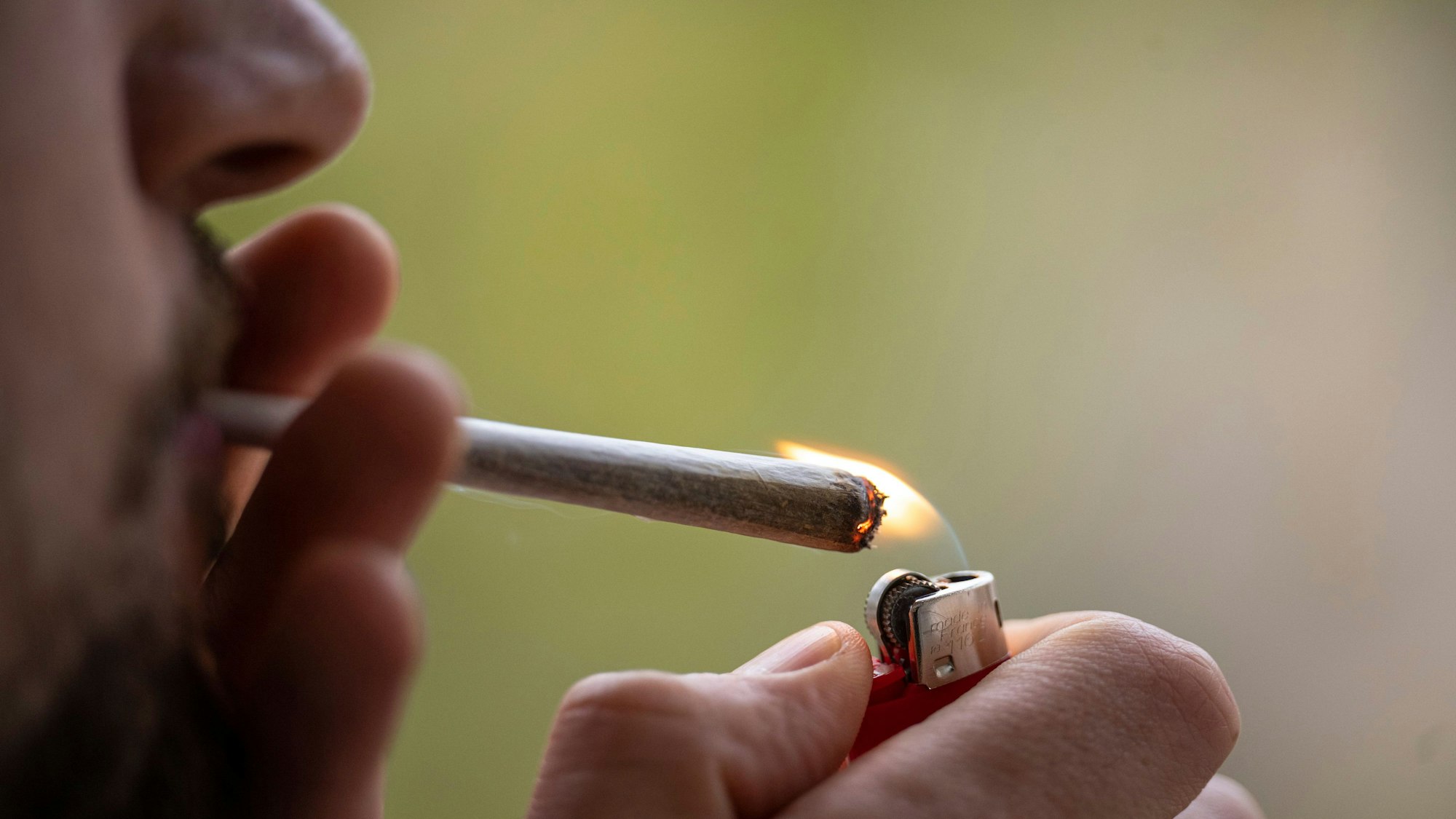 Ein Mann zündet sich einen Joint an. (Symbolbild)