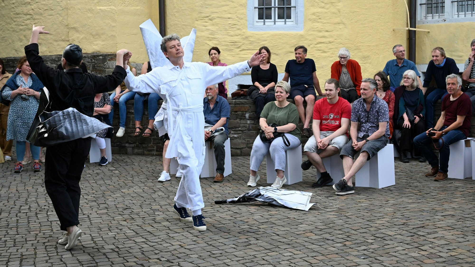 Eine Frau und ein Mann tanzen vor Zuschauern auf dem Hof von Schloss Homburg.