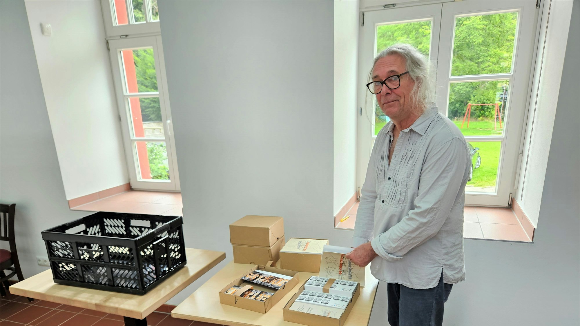 Jürgen Roder steht an einem Tisch mit Flyern.