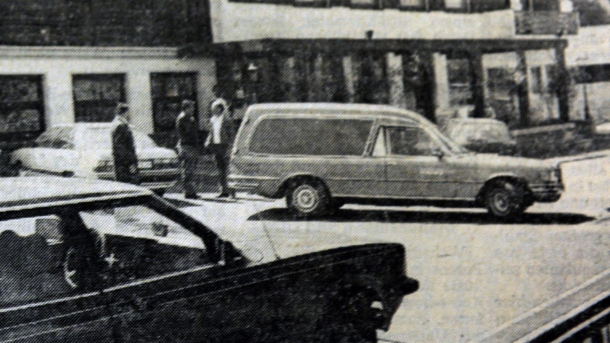 Ein Leichenwagen steht vor einer Gaststätte.