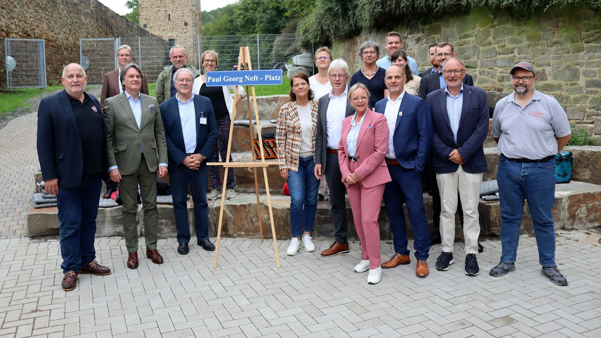 Die Gäste der Eröffnung des Grünen Klassenzimmers stehen um das Schild „Paul Georg Neft-Platz“.