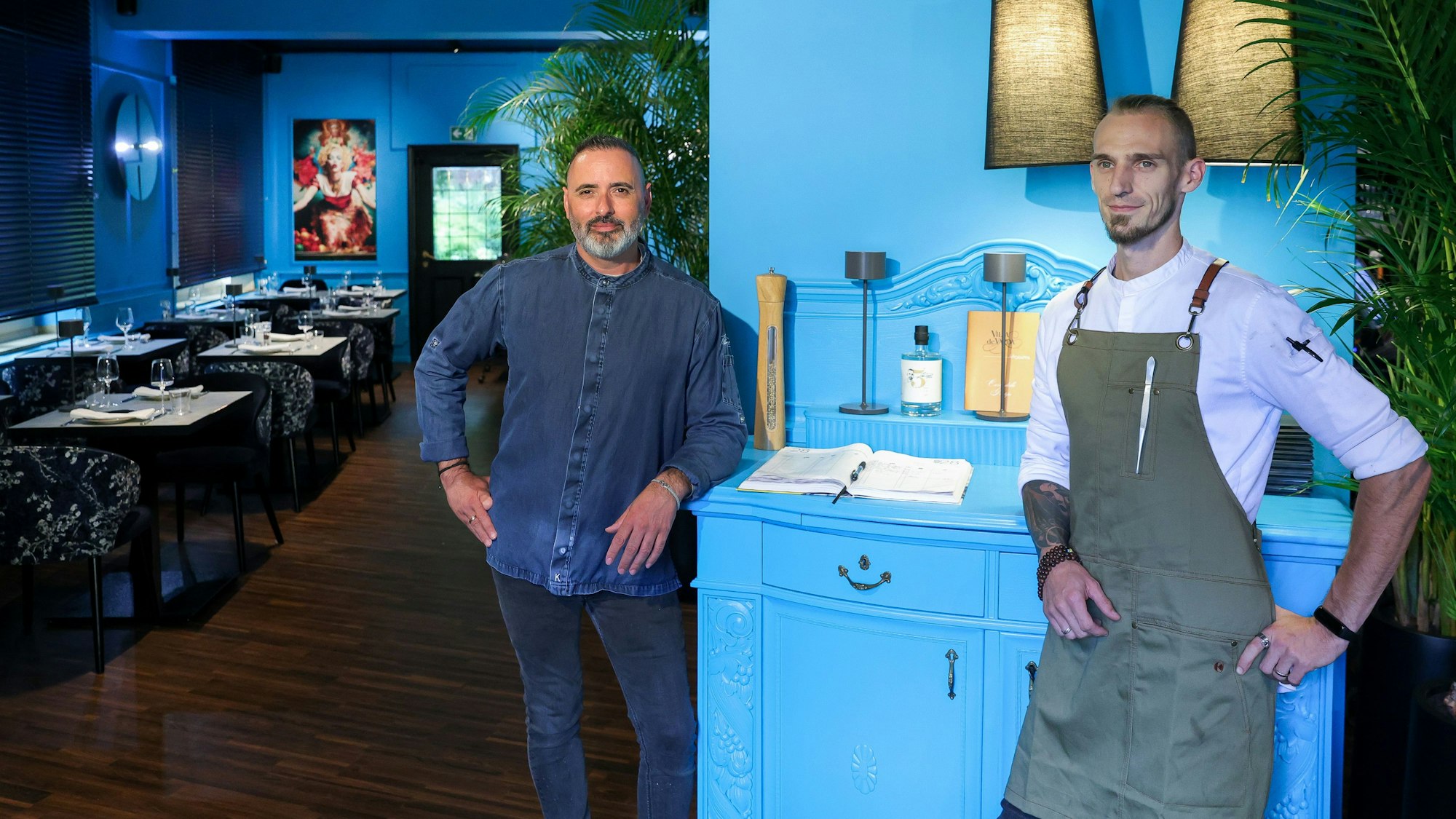 Luis Dias und Küchenchef Cyril Becker stehen in der neu eröffneten Weinbar vor einer türkisfarbigen Kommode.
