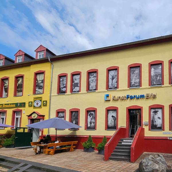 Auf dem Foto ist das Kunstforum Eifel mit den Bildern in den Fensteröffnungen zu sehen.