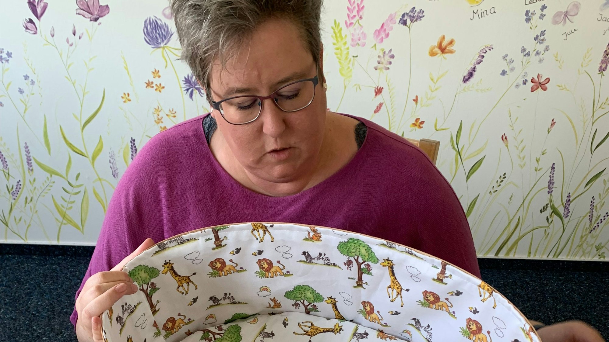 Eine Frau blickt in einen leeren Kindersarg.