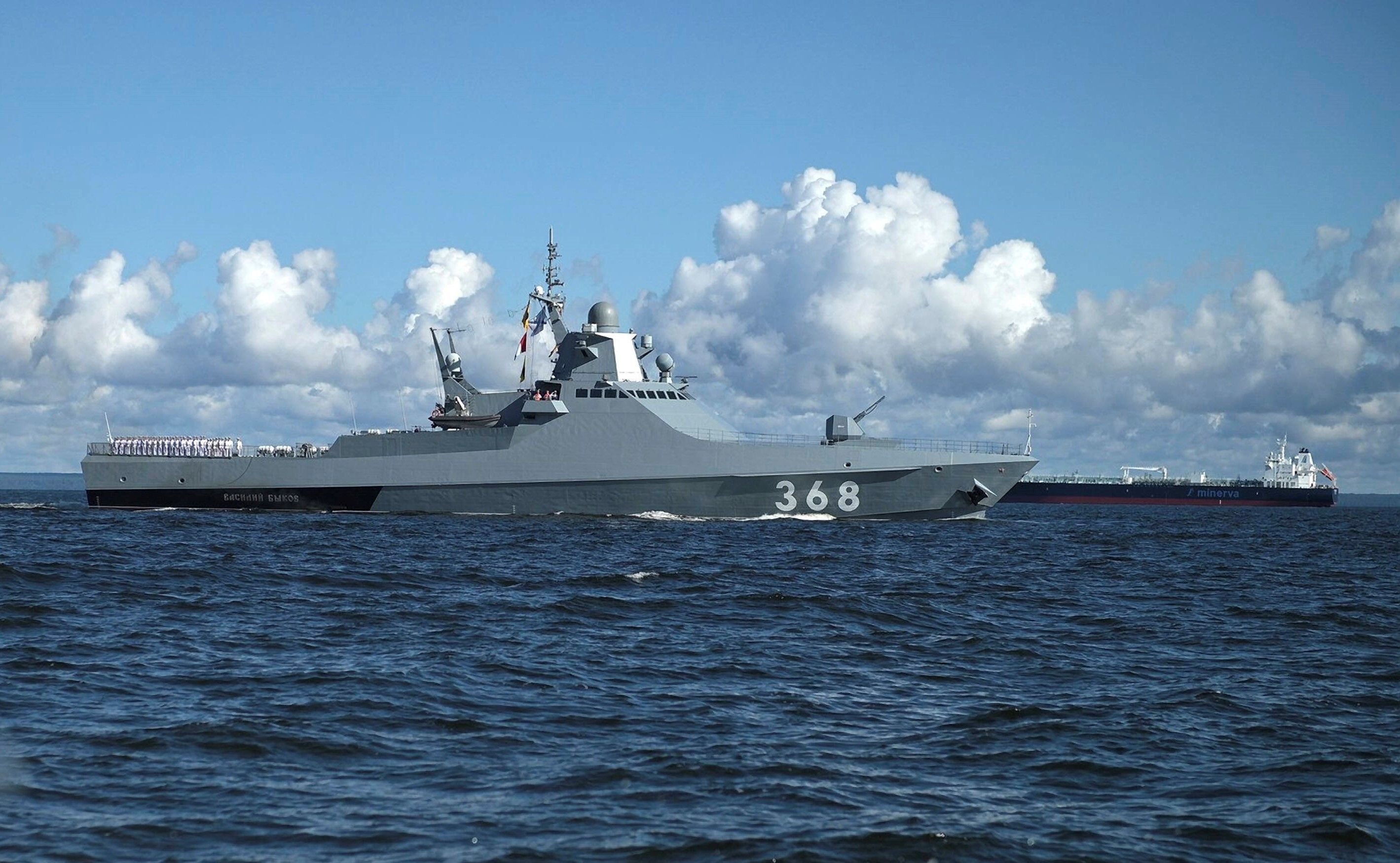 Das russische Patrouillenboot „Wassili Bykow“ bei einer Marine-Parade nahe St. Petersburg. Im Hintergrund ist ein Frachter zu sehen. Das Boot feuerte im Schwarzen Meer Warnschüsse ab, bevor Soldaten einen Frachter stürmten. (Archivbild)