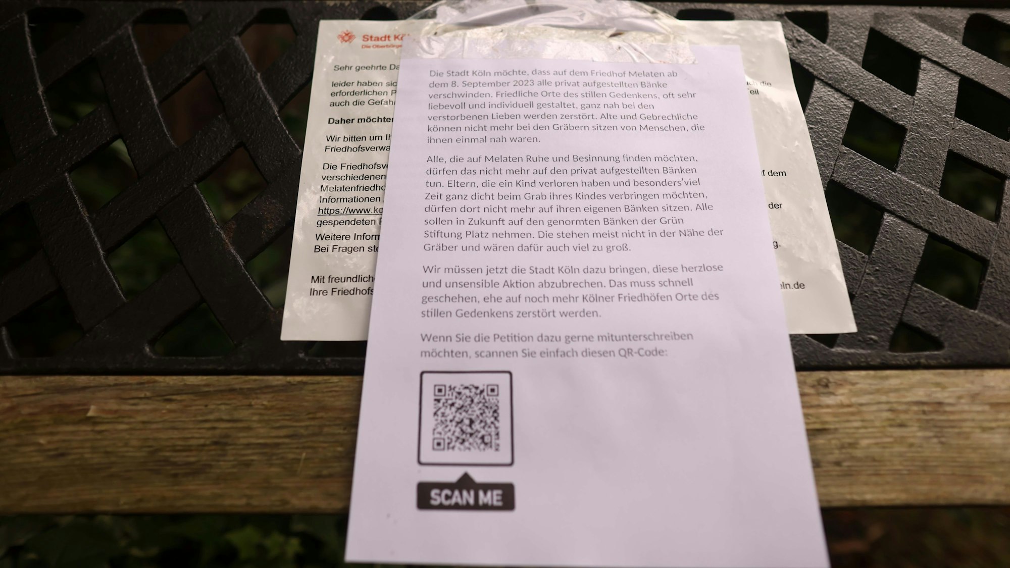 Der Aufruf, die Petition zu unterschreiben, klebt an einigen Bänken über der Aufforderung der Stadt, sie zu entfernen.