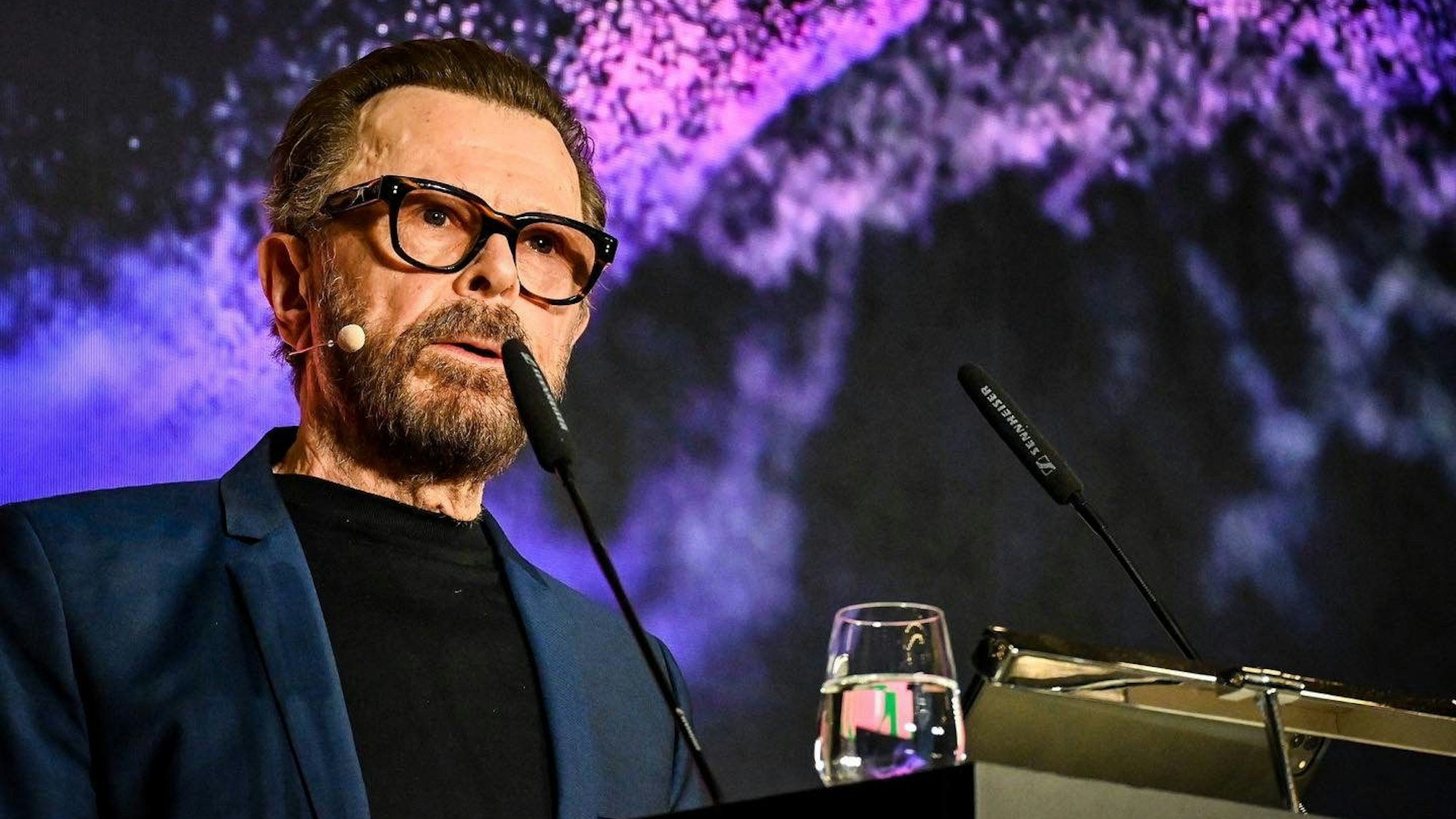 Björn Ulvaeus steht an einem Rednerpult.