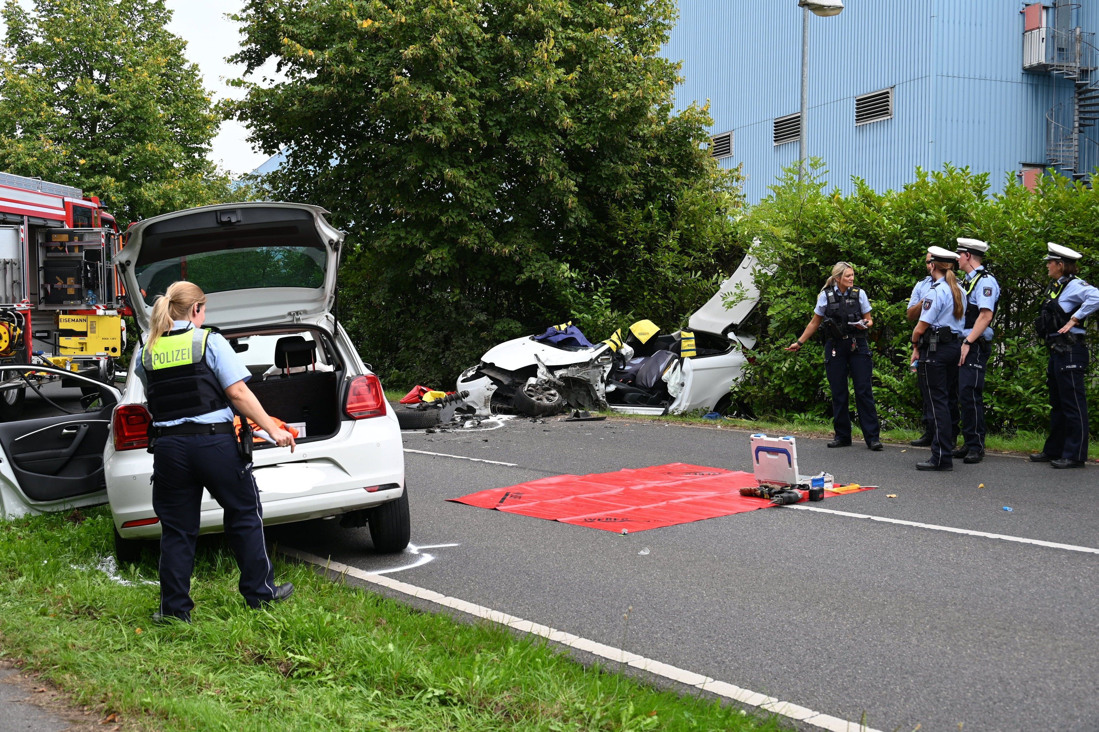 Polizisten vor einem Autowrack an der Bellerstraße.